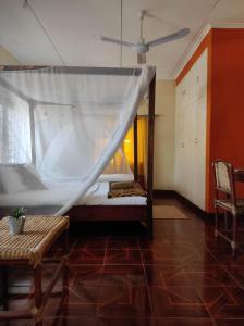 a bedroom with a bed with a mosquito net at Villa Liwonde - Cottage in Liwonde