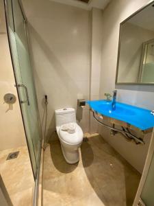 y baño con aseo y lavamanos azul. en Express Inn Bintulu en Bintulu