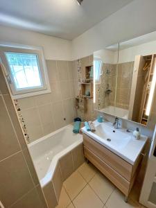 a bathroom with a tub and a sink and a mirror at Villa Confort Jacuzzi Barbecue Clim Parking in Marseille +25 photos
