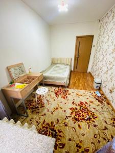 a room with a bed and a desk and a rug at Adventure Riders Mongolia in Ulaanbaatar