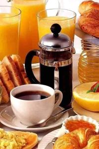 a breakfast table with a cup of coffee and pastries at Pukeko Nest in Russell