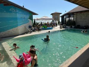 a group of children playing in a swimming pool at Hotel PANORAMA Kruje view over the castle and the old town in Krujë