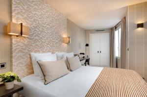 1 dormitorio con 1 cama blanca grande con almohadas en Le Senat, en París
