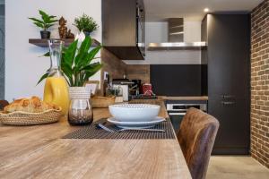 a kitchen with a table with a bowl of bread on it at Le Baleschoux - PrestiPlace Collection in Tours +22 photos
