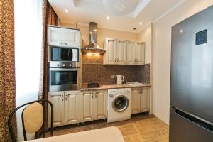 モスクワにあるCity Apartments Belorusskayaのキッチン(白いキャビネット、洗濯機、乾燥機付)