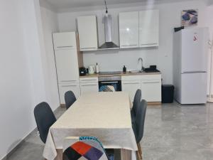 eine Küche mit einem Tisch und Stühlen sowie einem Kühlschrank in der Unterkunft Apartman Lena in Zadar