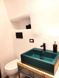a bathroom with a green sink and a toilet at Minuetto 16 in Ostuni