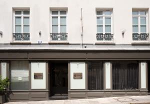 una fachada de un edificio blanco con ventanas en Le Senat, en París