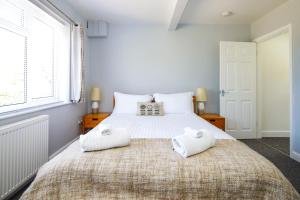 a bedroom with a large bed with two towels on it at Ground floor flat with parking, sleeps 3 in Wheatley