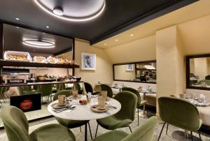 un restaurante con mesas, sillas verdes y una barra en Le Senat, en París