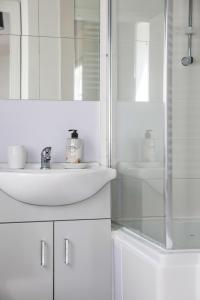 a white bathroom with a sink and a mirror at Ground floor flat with parking, sleeps 3 in Wheatley