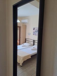 a mirror reflection of a bed in a room at Diolkos 2 in Nea Roda