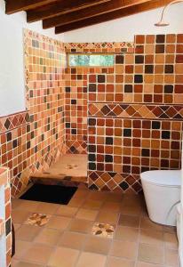 a tiled bathroom with a toilet and a window at Villa Mazarello in El Retiro