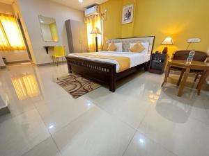 a large bedroom with a bed and a table at Hotel Prime Classic in Shamshabad