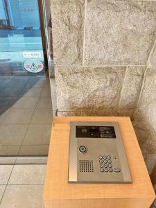 a remote control sitting on top of a wooden table at 三米-黒門市場-黑门市场-kuromon 202タイプ in Osaka