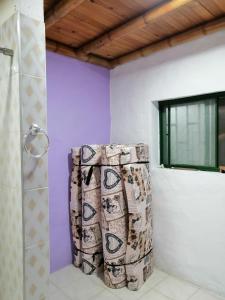 a bathroom with purple walls and a shower curtain at Casa el edén in Choachí