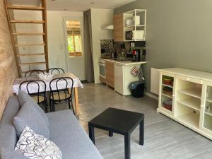 sala de estar con sofá, mesa y cocina en Gîte de Kermoal-location de vacances, en Poullan-sur-Mer