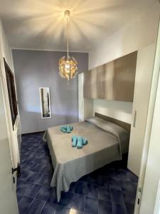 a bedroom with a bed with two blue towels on it at Casa Gabry e Lory in Fort Village