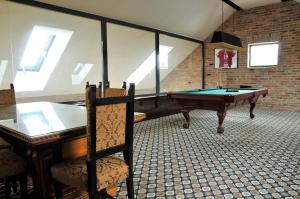 um quarto com uma mesa de bilhar num quarto com janelas em Hotel Castello & Thermal Spa Siklós em Siklós