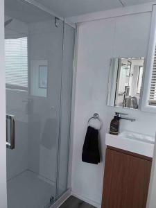 a bathroom with a glass shower and a sink at Tiny home in the hills 