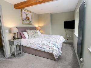 a bedroom with a bed and a flat screen tv at The Lookout in Holmfirth