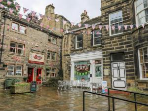 a group of buildings with tables and chairs in the street at The Lookout in Holmfirth