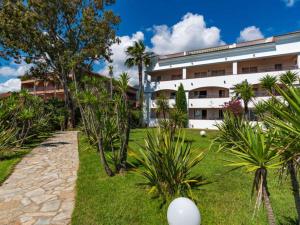 a building with palm trees in front of a yard at Vacances en Corse in San-Nicolao