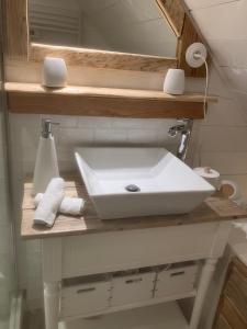 La salle de bains est pourvue d'un lavabo blanc sur un comptoir. dans l'établissement Retour de plage, à Locmaria