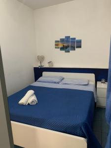 ein Schlafzimmer mit einem Bett mit einer blauen Decke in der Unterkunft Valentina Holiday House in Mascali