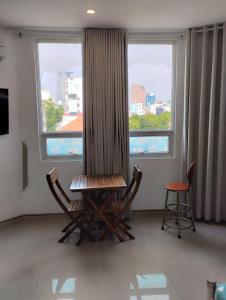 a room with two chairs and a table and two windows at Dragon homestay centre city Bitexco view room in Ho Chi Minh City