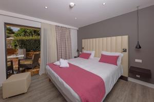 una camera da letto con un grande letto con cuscini rosa di Hotel Saint Christophe a Calvi