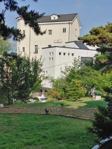 a large white building in the middle of a park at The Castle Stay in Chuncheon
