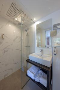 a bathroom with a sink and a mirror at Hotel Saint Christophe in Calvi