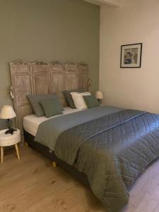 a bedroom with a large bed with a wooden headboard at La Tuilerie in Verteuil-sur-Charente