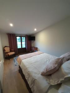 Un dormitorio con una cama grande y una ventana en Les Cottages du Chateau de Werde, en Matzenheim