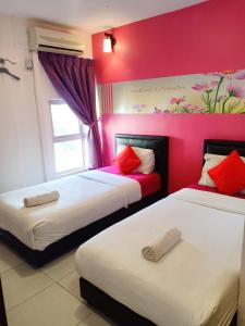 2 łóżka w pokoju z różowymi ścianami w obiekcie Sweet Memories Hotel w Malakce
