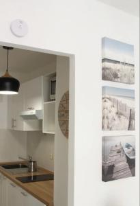 una cocina con armarios blancos y fregadero en Beach Studio Juan Les Pins, en Antibes