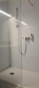 eine Duschkabine mit Glastür mit Dusche in der Unterkunft Aparthotel Apartamenty Czarna Góra 403 in Heudorf