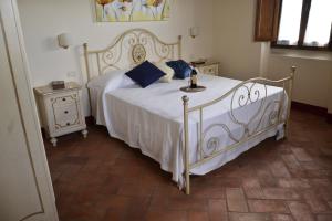 a bedroom with a white bed with blue pillows at Agriturismo la Concezione in Castiglion Fibocchi