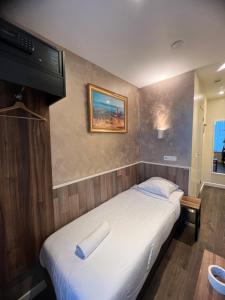 1 dormitorio con 1 cama y TV en la pared en Orange Tulip Hotel, en Ámsterdam