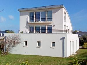 ein weißes Haus mit Balkon darüber in der Unterkunft Villa Inizan in Loctudy