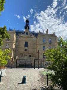 a large building with a fence in front of it at Paris-Eiffel, bienvenue -terrasse -Netflix in Pantin