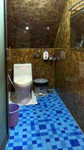 a bathroom with a toilet and a blue tiled floor at Phu Nam House - Resort in Phú Quốc