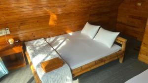 a small bed in a room with wooden walls at Phu Nam House - Resort in Phú Quốc