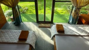 a bedroom with two beds in front of a window at Phu Nam House - Resort in Phú Quốc