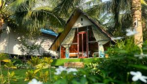 una casa con una puerta roja y una palmera en Phu Nam House - Resort en Phu Quoc