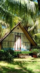 a small house with a window and a palm tree at Phu Nam House - Resort in Phú Quốc