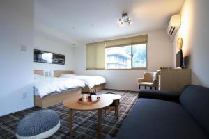una camera d'albergo con letto e divano di スイートステイ京都 Suite Stay Kyoto a Kyoto