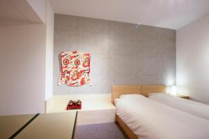 京都的住宿－スイートステイ京都 Suite Stay Kyoto，一间小卧室,配有两张床和一张桌子