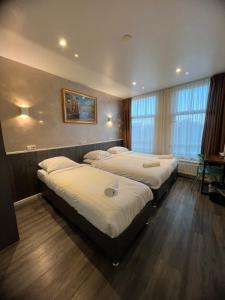een slaapkamer met 3 bedden in een kamer bij Orange Tulip Hotel in Amsterdam